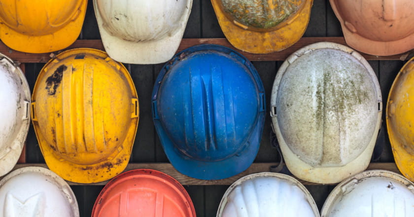 Construction site hardhats hanging on a wall