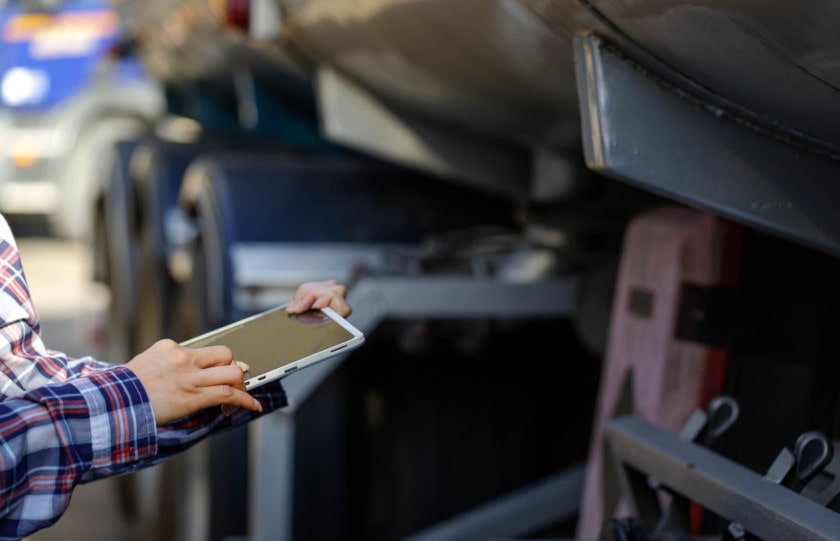 Truck driver performs a pre-trip inspection on her mobile device.