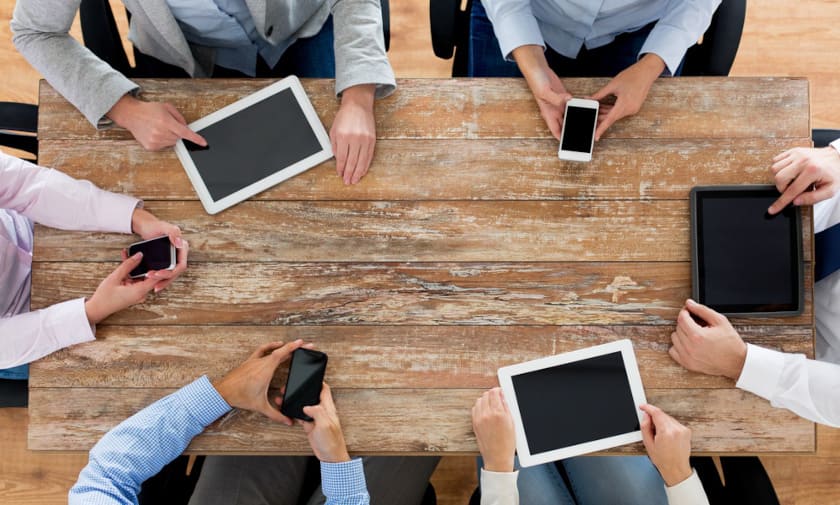 People using a tablet around a table